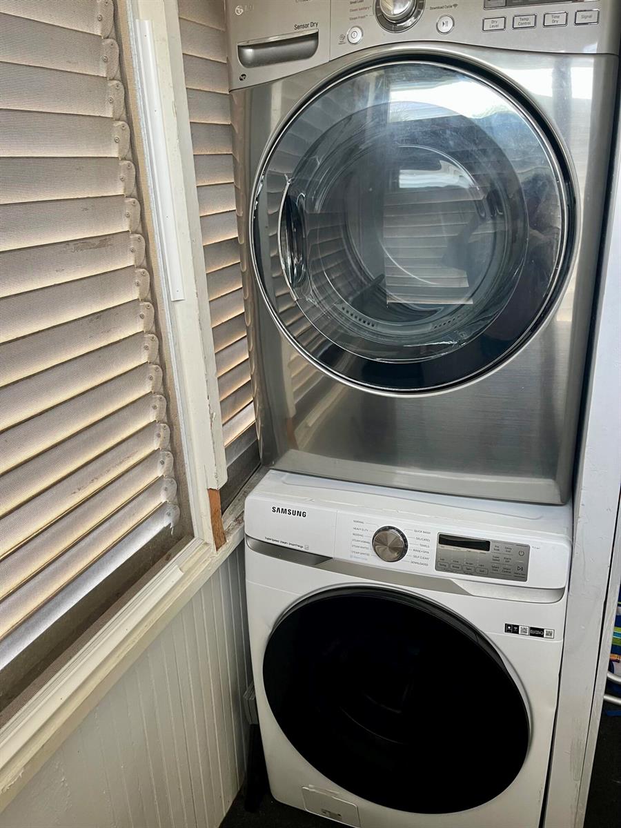 A stacked LG dryer and Samsung washing machine are positioned in a corner near blinds — 711 S N Street # 1, FL 33460, FL