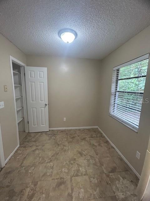 A small room features tan walls, tile flooring, a white door, and a window with blinds — 1509 CARDINAL STREET, LONGWOOD, FL