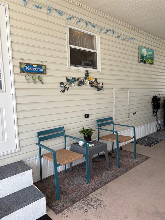A patio area features two teal chairs, a small table, and wall-mounted decorative accents — 10297 N LAKE DRIVE UNIT 79, LARGO, FL