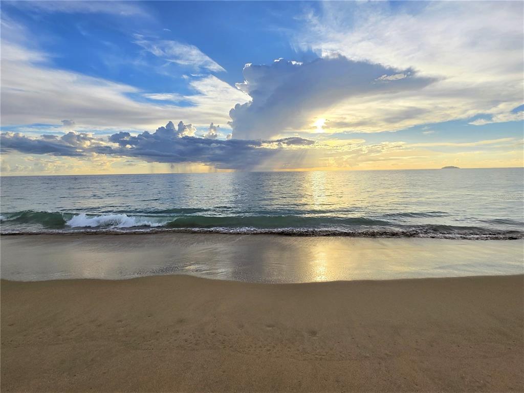 A sandy beach meets the ocean under a cloudy sunset sky — 23 CASA CANAL, RINCON, PR