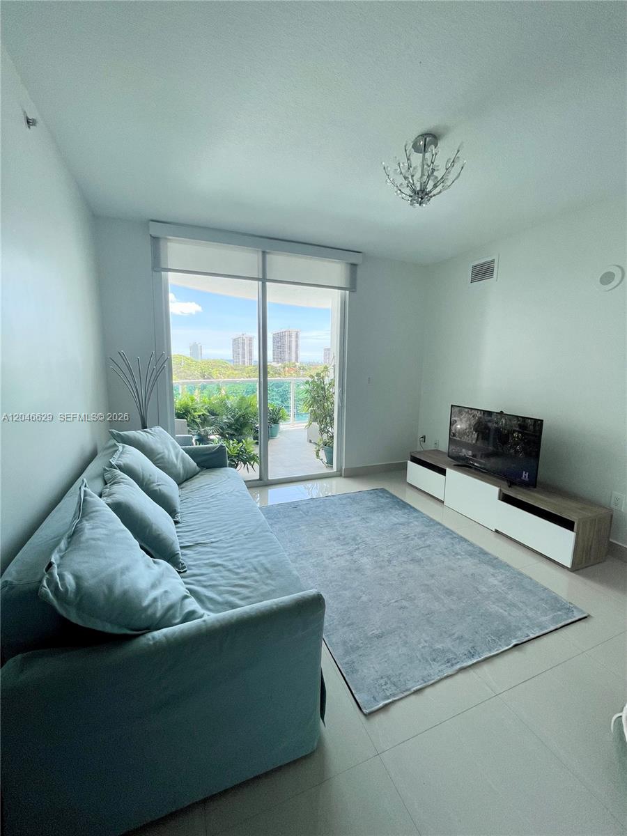 A living room features a light blue sofa, a gray area rug, and a balcony — 1723 SW 2nd Ave # 801, Miami FL 33129, MIAMI, FL