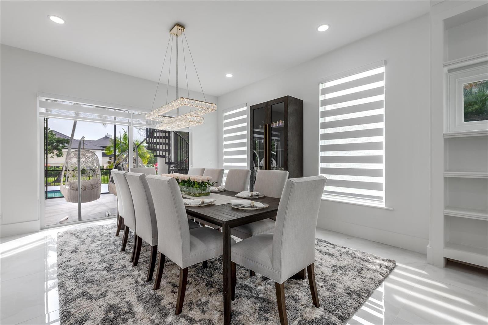 A dining room features a dark wood table, eight upholstered chairs, and a crystal chandelier — 2090 Windsock Way, Wellington FL 33414, WELLINGTON, FL