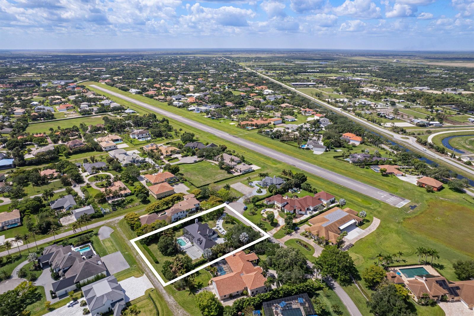 An aerial view shows a residential property with a pool highlighted by a white border — 2090 Windsock Way, Wellington FL 33414, WELLINGTON, FL