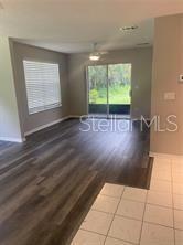 An open living area features wood-look flooring, a ceiling fan, and sliding glass patio doors — 713 SANDY COURT UNIT 375, ALTAMONTE SPRINGS, FL