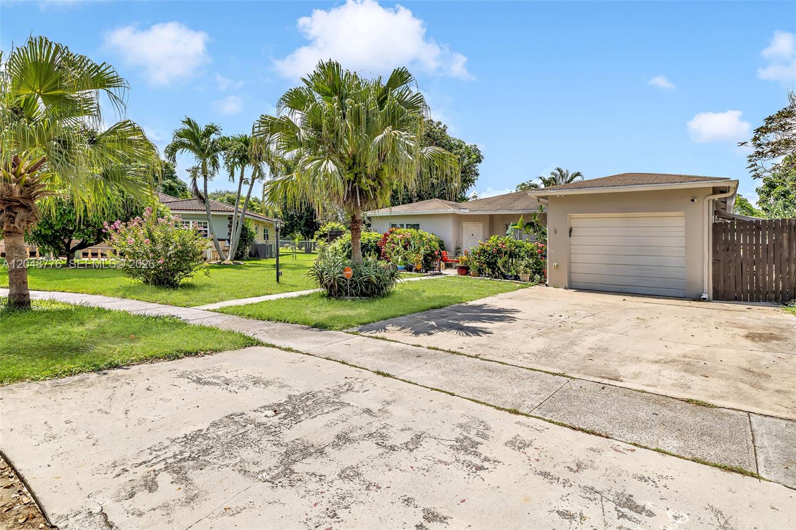 A single-story house with a concrete driveway, a garage, and palm trees in the yard — 5045 SW 10th St, Margate FL 33068, MARGATE, FL