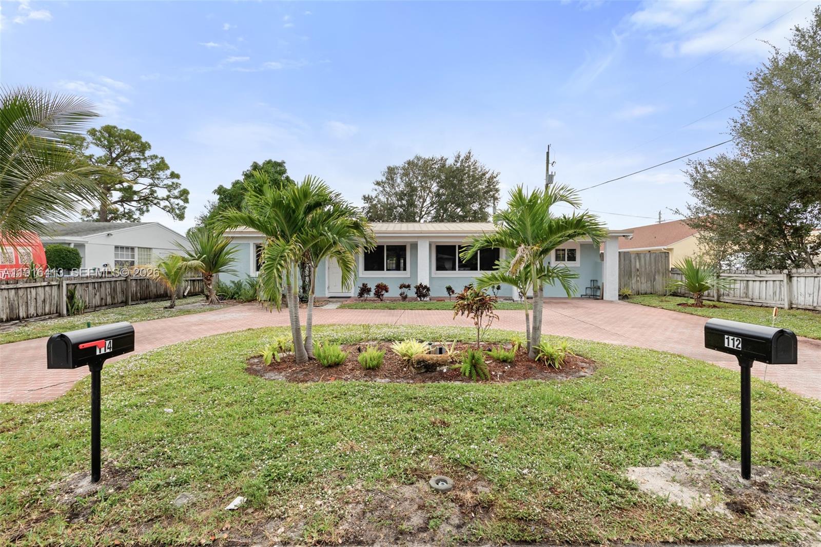 A light blue single-story house features a circular driveway and two mailboxes in the front — 112 Milton St # 112, Lantana FL 33462, LANTANA, FL