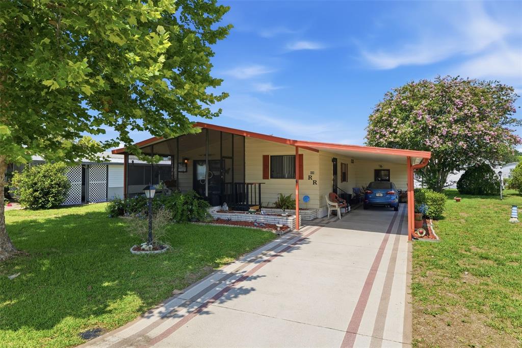 A single-story house with a screened porch, carport, and a concrete driveway — 409 TIVOLI PARK DRIVE, DAVENPORT, FL