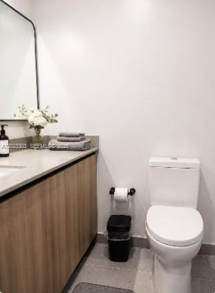 A modern bathroom features a light wood vanity, a white toilet, and a framed mirror — 121 NE 5th St # 3203, Miami FL 33132, MIAMI, FL