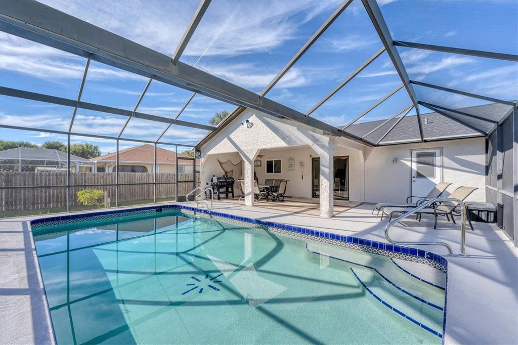 A swimming pool with a screened enclosure and a covered patio area — 18091 EAU GALLIE CIRCLE, PORT CHARLOTTE, FL