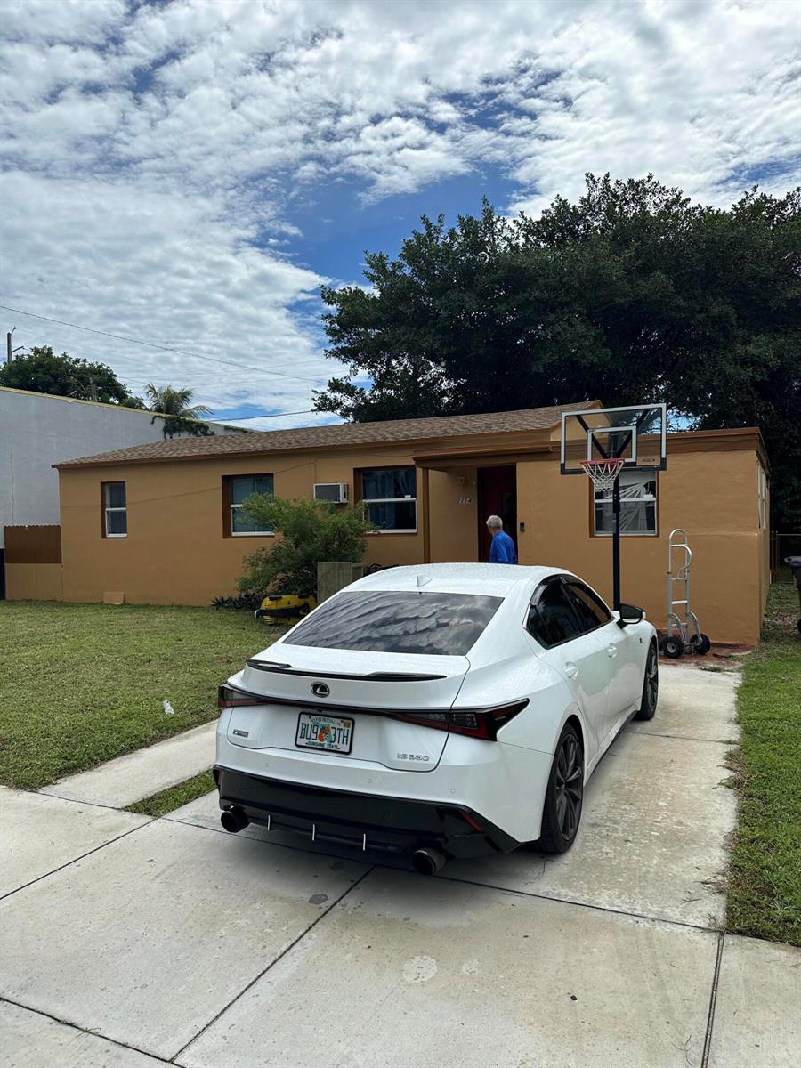 A white Lexus sedan is parked in the driveway of a single-story tan house — 2114 Dewey Street, Hollywood FL 33020, HOLLYWOOD, FL