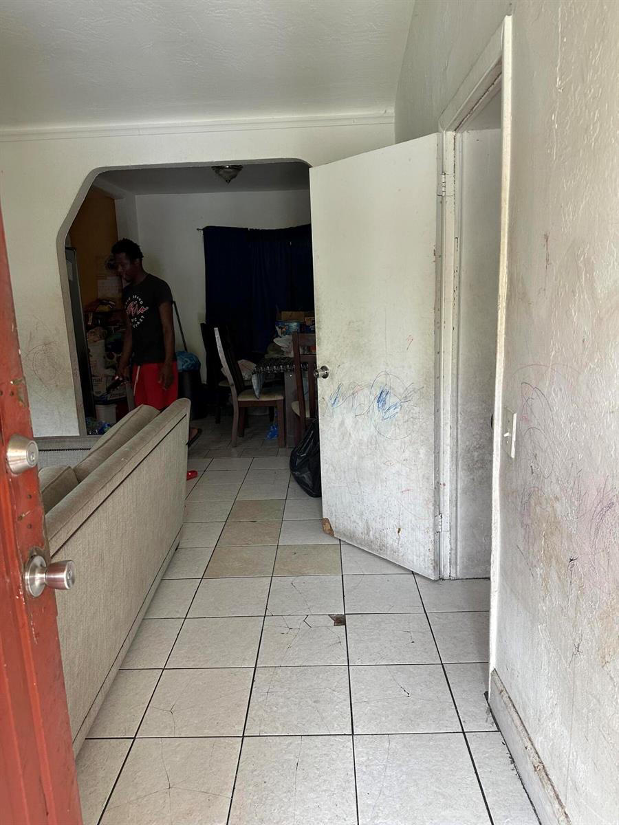 A view from a doorway into a living area with tiled floors and marked walls — 2114 Dewey Street, Hollywood FL 33020, HOLLYWOOD, FL