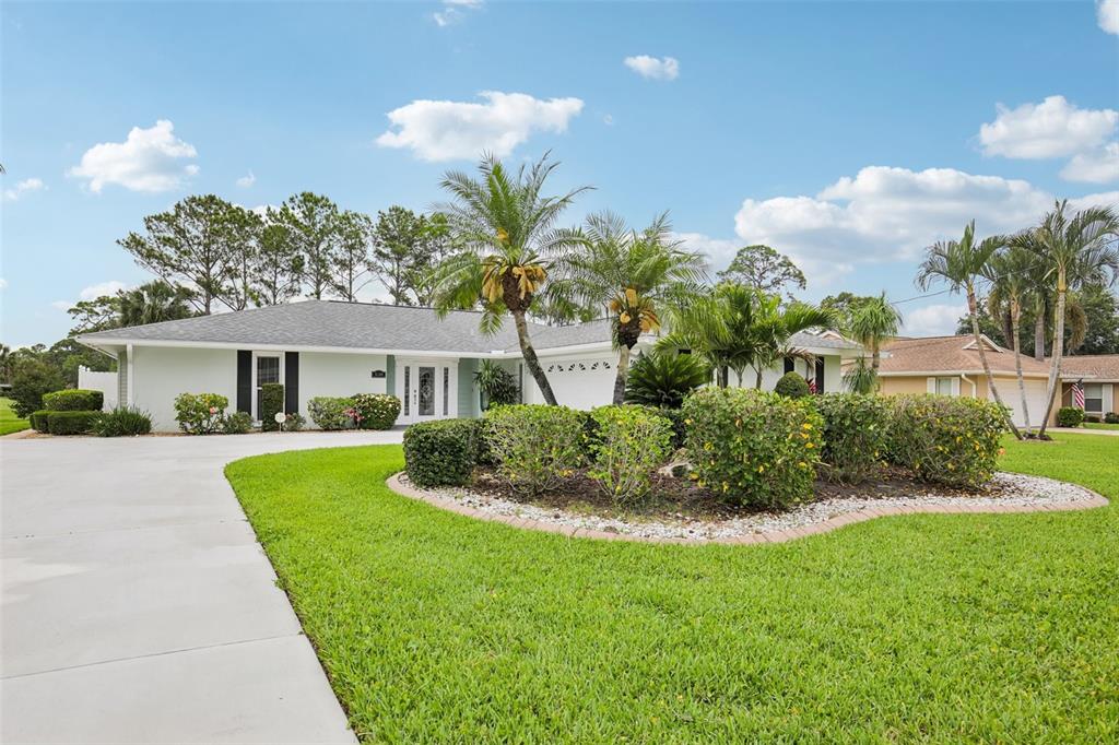 A single-story house with a light-colored exterior, palm trees, and a landscaped front yard — 530 MAGELLAN DRIVE, SARASOTA, FL