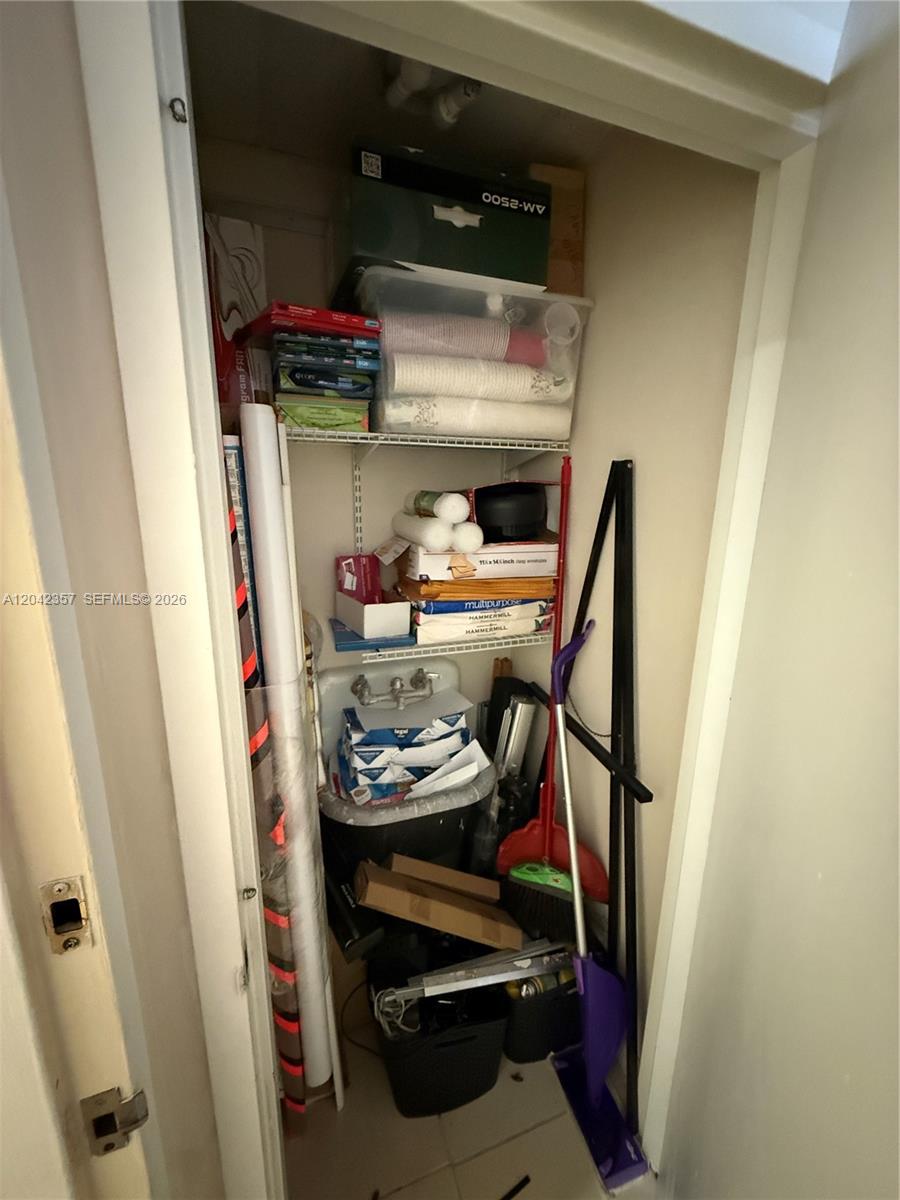 This utility closet contains a sink, shelving units, and various household storage items — 9600 NW 25th St # 4H, Doral FL 33172, DORAL, FL
