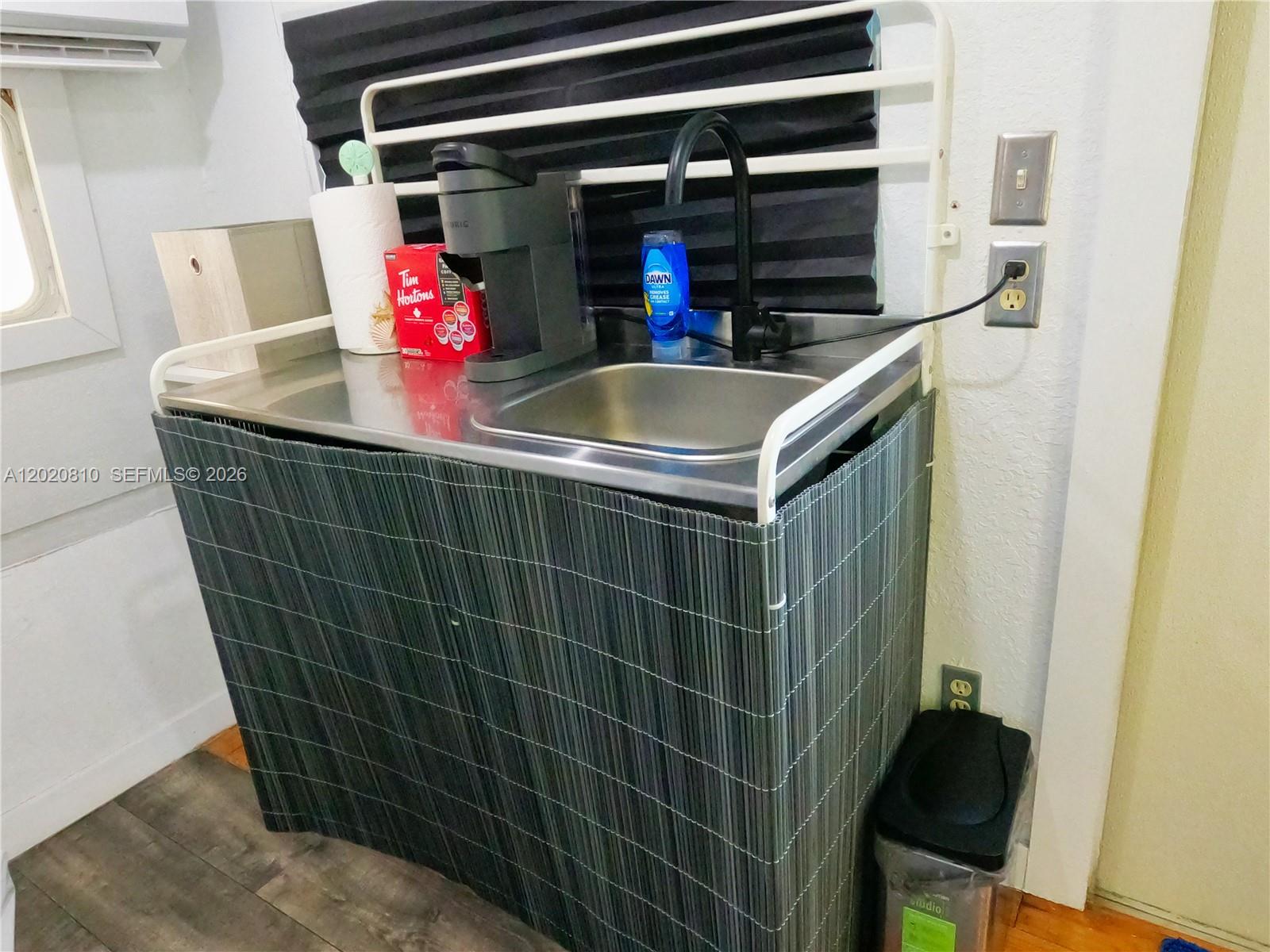 A stainless steel sink unit with a coffee maker sits against a wall — KEY LARGO, FL