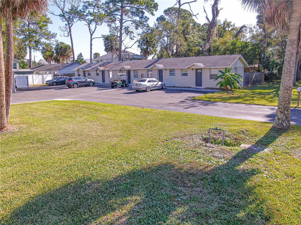 A single-story apartment building with a parking lot and lawn in the foreground — 7618 US HIGHWAY 19, NEW PORT RICHEY, FL