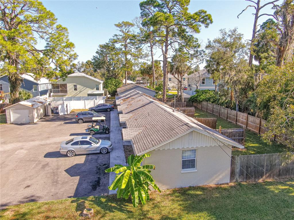 An aerial view shows a long, single-story apartment building with a parking lot and trees — 7618 US HIGHWAY 19, NEW PORT RICHEY, FL