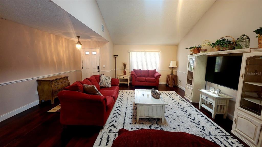 A living room features red sofas, a white coffee table, and a large entertainment center — 10 BLACKFOOT COURT, PALM COAST, FL