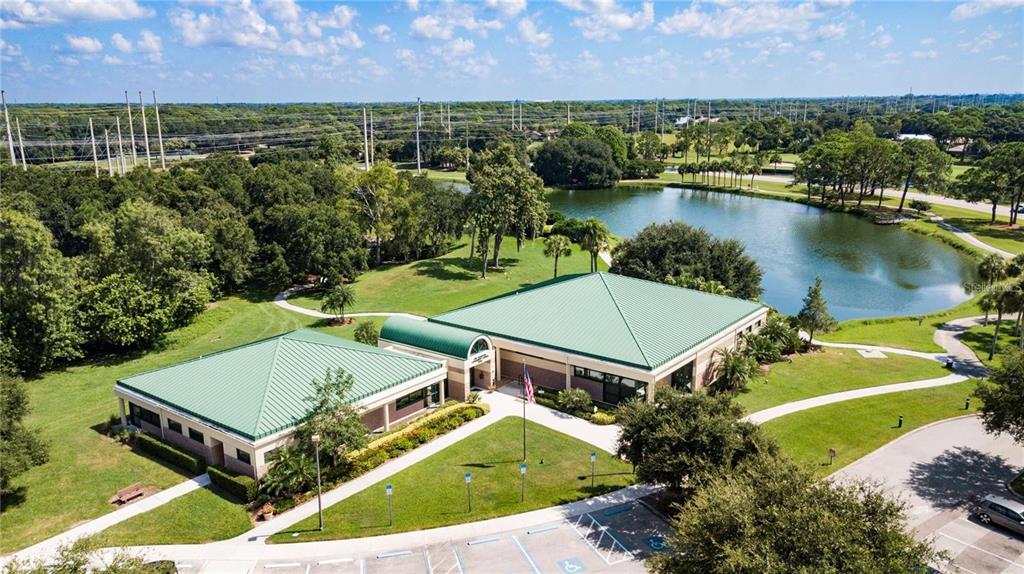 An aerial view of a commercial building with a green roof next to a pond — 5147 WILLOW LINKS UNIT 18, SARASOTA, FL
