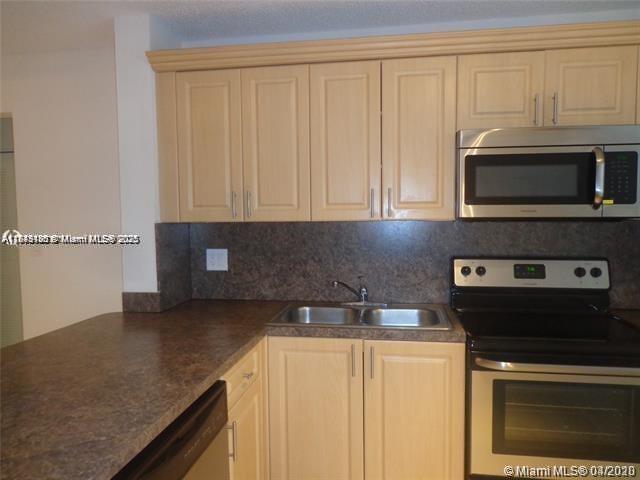 A kitchen features light wood cabinets, a dark laminate countertop, and stainless steel appliances — 2276 SW 81st Ave # 2276, Miramar FL 33025, MIRAMAR, FL