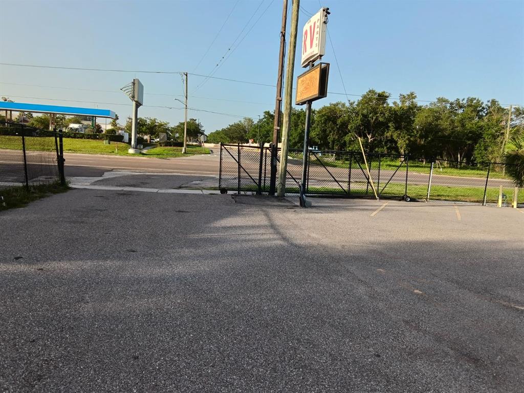 An asphalt parking lot leads to a gated entrance with an RV parts sign — 9006 GIBSONTON DRIVE, GIBSONTON, FL