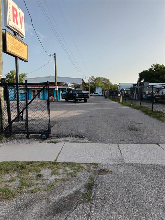 A paved parking lot leads to a commercial building with a blue exterior and signage — 9006 GIBSONTON DRIVE, GIBSONTON, FL