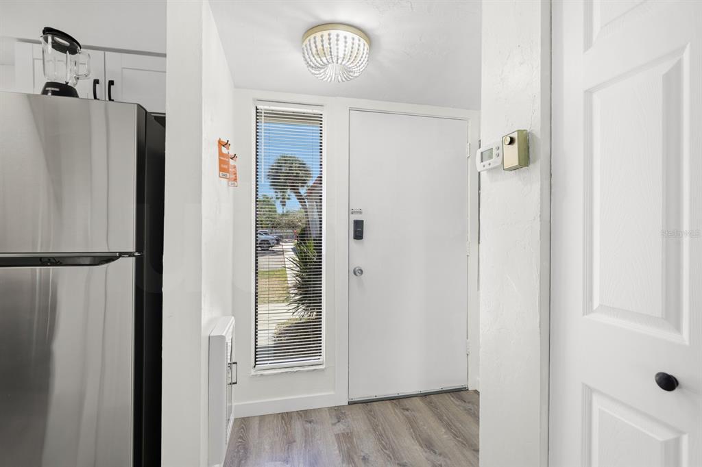 A white kitchen features a farmhouse sink, stainless steel appliances, and dark hardware — 1801 GULF DRIVE N UNIT 184, BRADENTON BEACH, FL