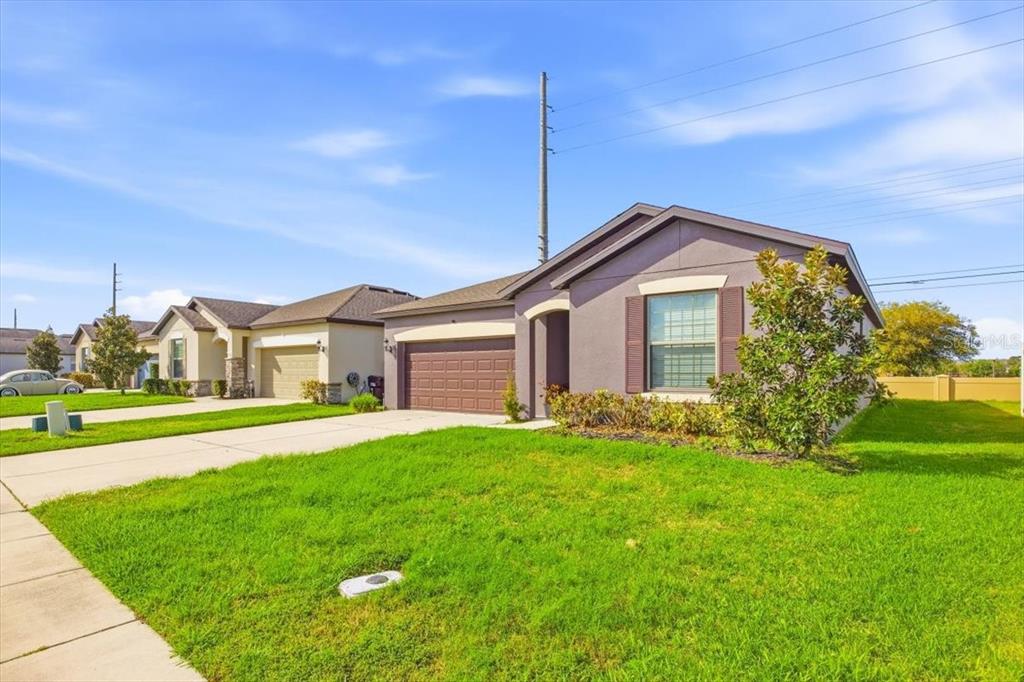 A single-story suburban house with a brown garage and a green lawn — 1917 CAYMAN COVE CIRCLE, ST CLOUD, FL