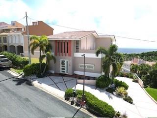 A multi-story house with a paved driveway and palm trees overlooks the ocean — 1 SHELL CASTLE CLUB UNIT 86, HUMACAO, PR
