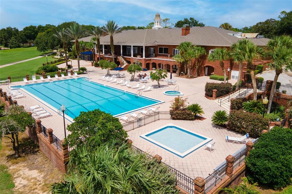 An aerial view of a brick clubhouse featuring a large swimming pool and patio area — 6200 TOPSAIL ROAD, LADY LAKE, FL