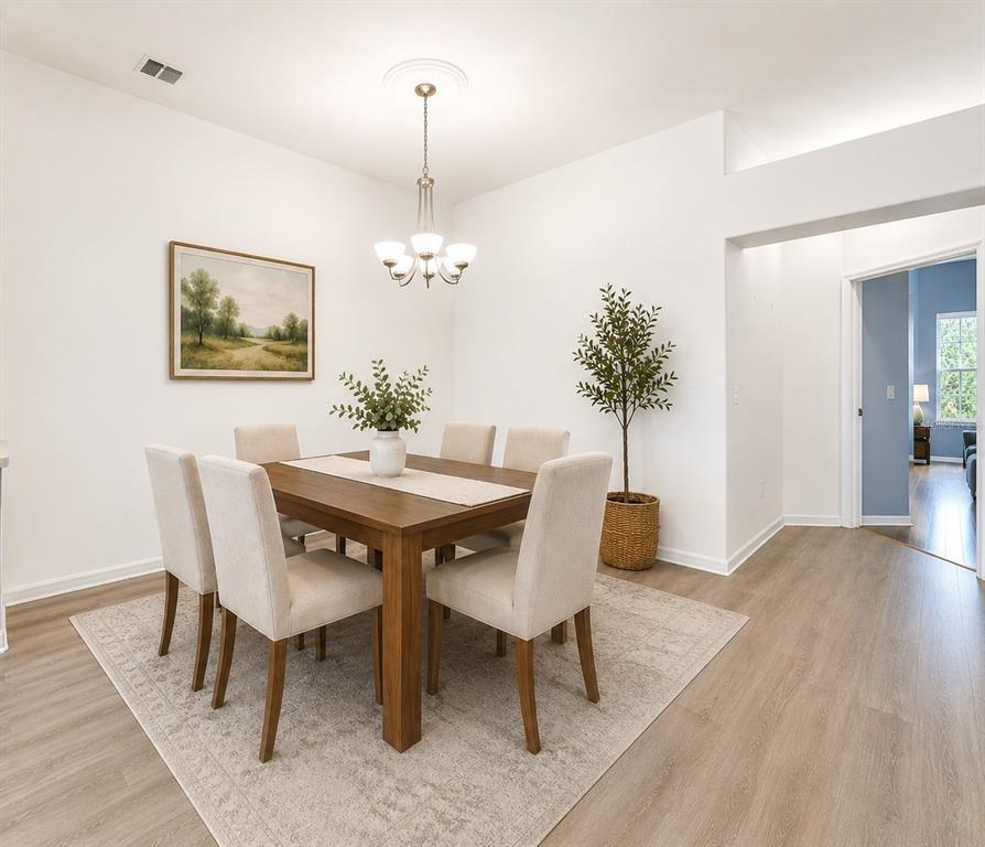 A dining room features a wooden table with six upholstered chairs on a light rug — 6200 TOPSAIL ROAD, LADY LAKE, FL