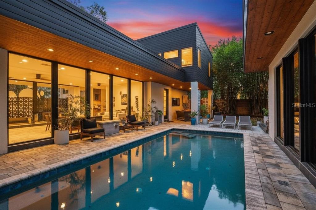 A modern two-story home features a rectangular swimming pool and a paved patio area — 2506 WOODSIDE AVENUE, ORLANDO, FL