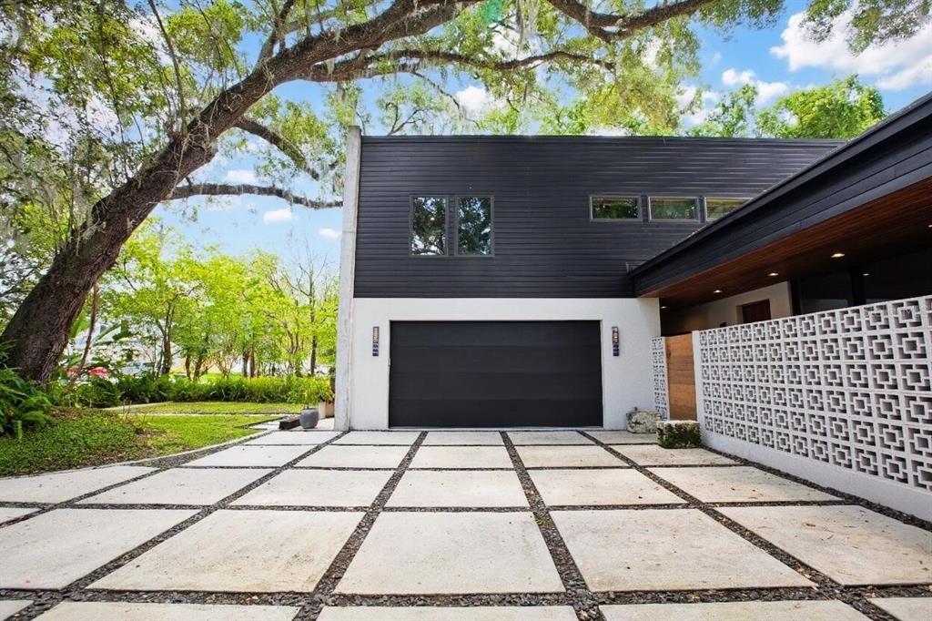 A modern home exterior features a black garage, white walls, and a concrete paver driveway — 2506 WOODSIDE AVENUE, ORLANDO, FL