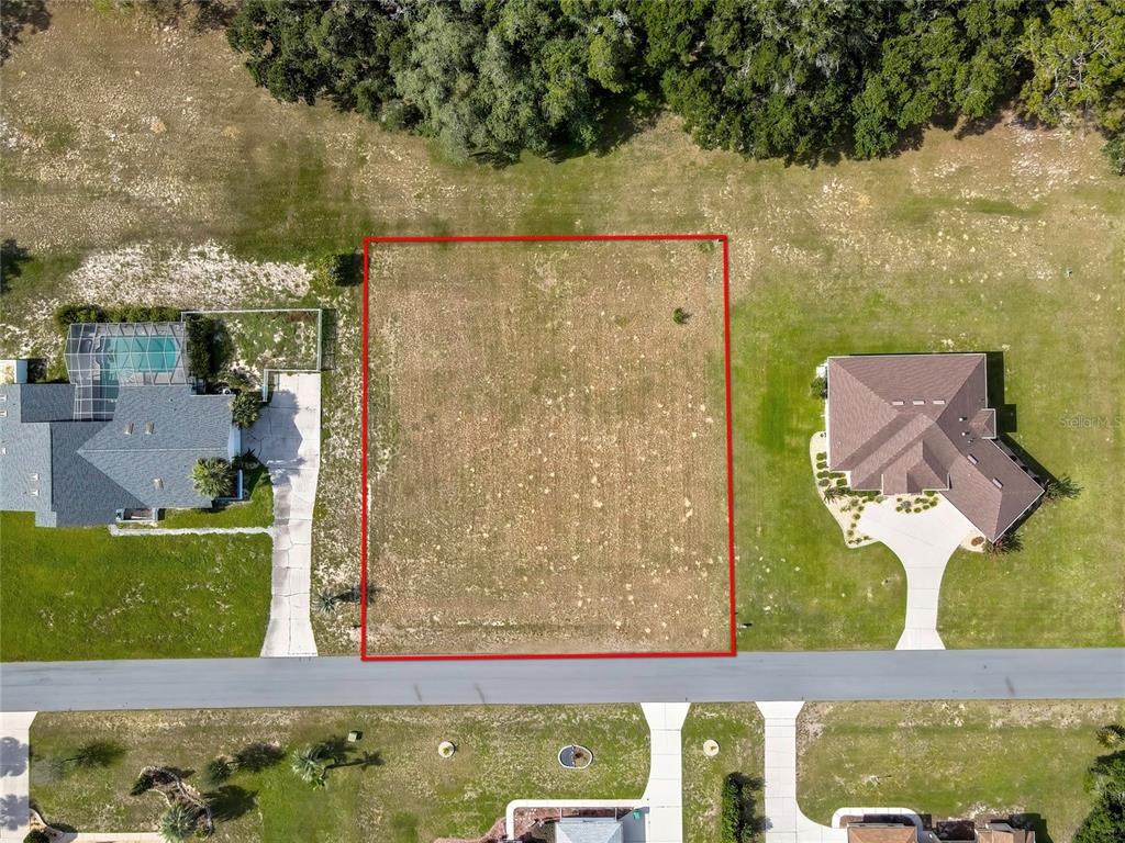 An aerial view shows a vacant rectangular lot outlined in red between two houses — 368 E FALCONRY COURT, HERNANDO, FL