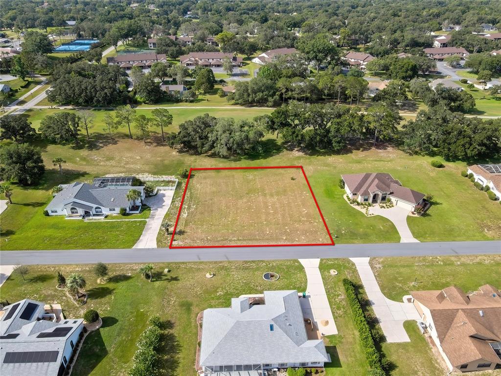 An aerial view shows a vacant rectangular lot situated between two single-family homes — 368 E FALCONRY COURT, HERNANDO, FL