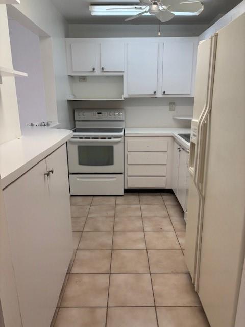 A galley kitchen features white cabinets, a white stove, and light-colored tile flooring — 1421 S Ocean Boulevard # 218, Pompano Beach FL 33062, POMPANO BEACH, FL