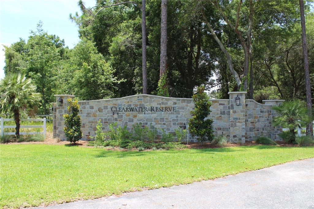 A stone entrance sign for Clearwater Reserve stands in front of trees and a lawn — 3117 BRIGHT LAKE CIRCLE lot 63, GROVELAND, FL