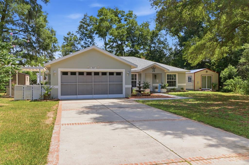 A single-story house with a garage, a concrete driveway, and a detached shed in the yard — 8667 N UPLAND DRIVE, CITRUS SPRINGS, FL