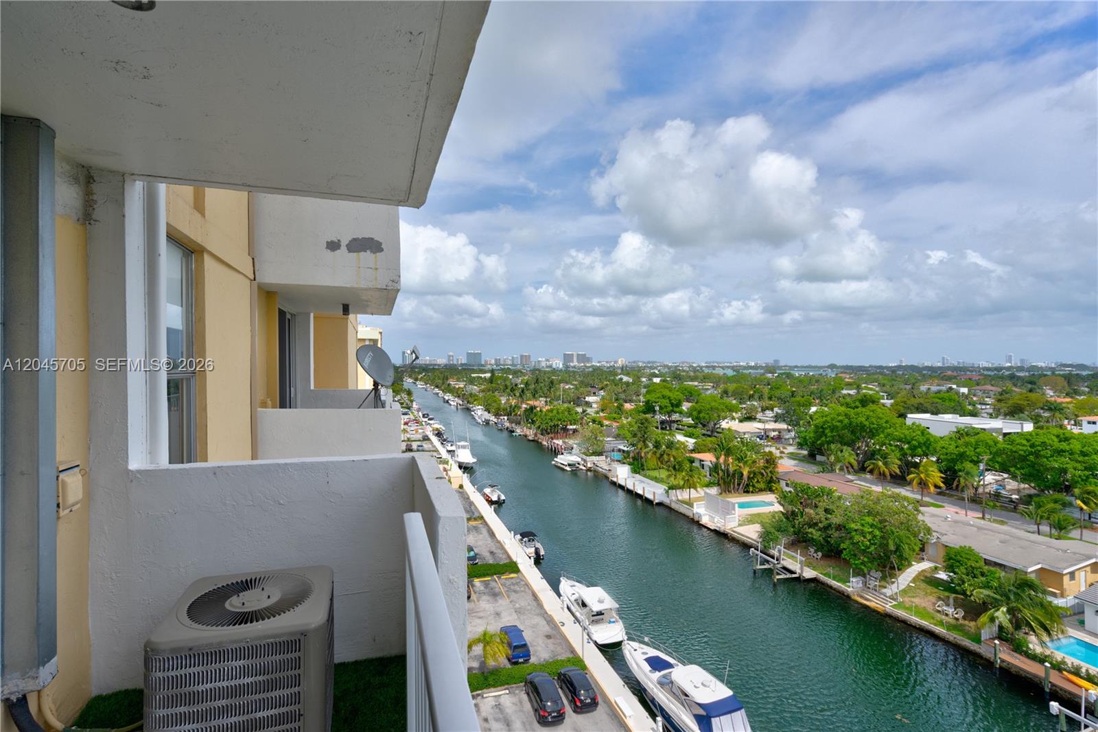 A high-angle view from a balcony overlooking a canal with docked boats and buildings — 2000 NE 135th St # 908, North Miami FL 33181, NORTH MIAMI, FL
