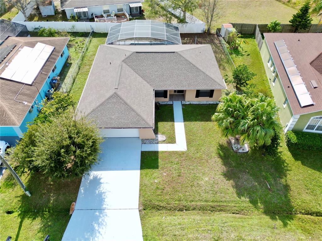 An aerial view shows a single-story house with a shingled roof, driveway, and pool enclosure — 620 HERALDO COURT, KISSIMMEE, FL