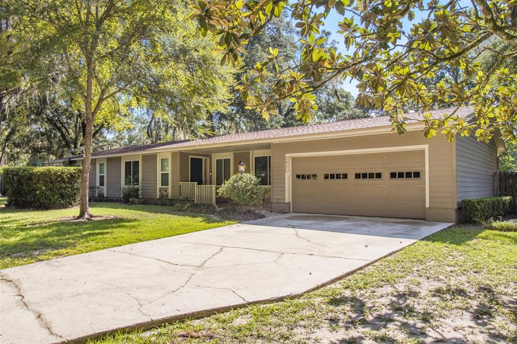 A single-story house with tan siding, a two-car garage, and a concrete driveway — 2925 NW 31ST TERRACE, GAINESVILLE, FL