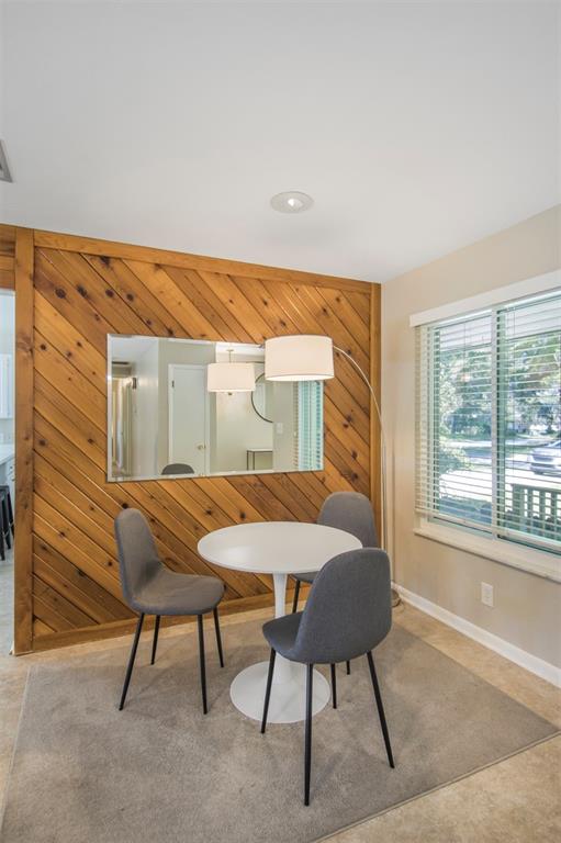 A dining area features a round white table, three gray chairs, and diagonal wood paneling — 2925 NW 31ST TERRACE, GAINESVILLE, FL