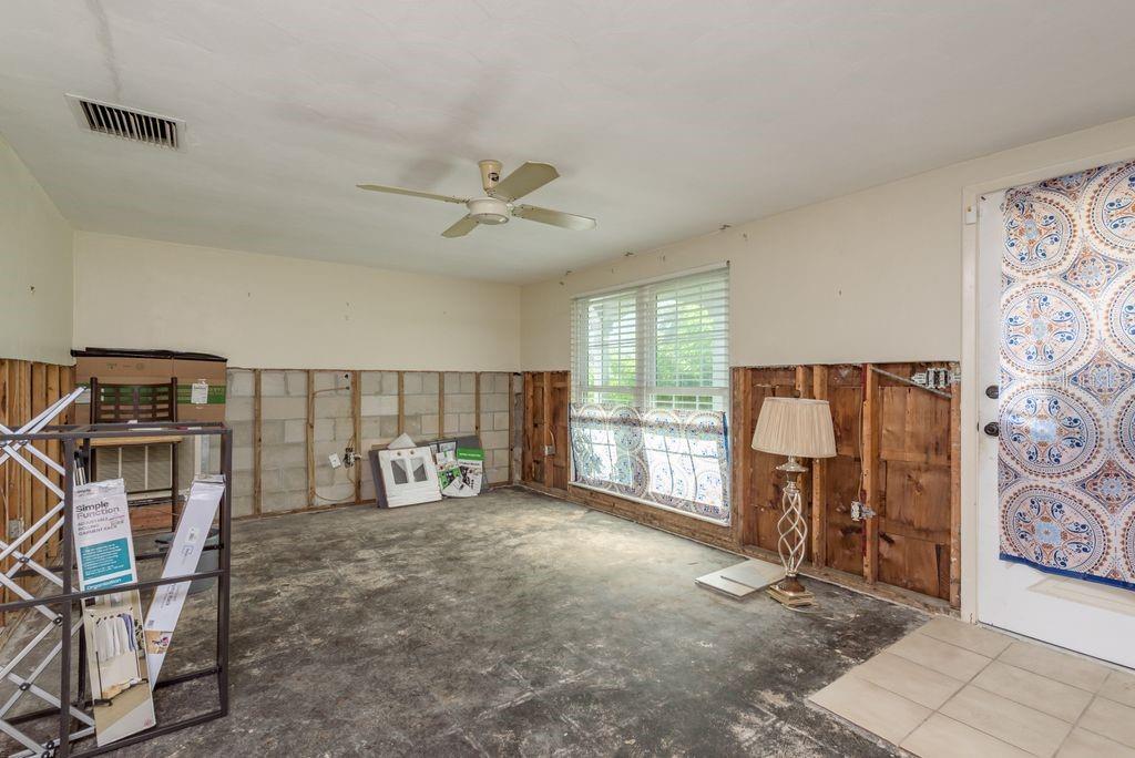 An unfinished room with exposed wall studs, a ceiling fan, and a concrete floor — 3552 BLUEBELL LANE, HOLIDAY, FL