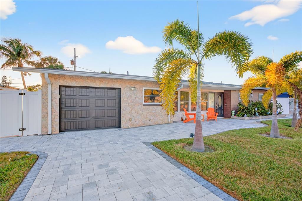 A single-story house with a stone facade, a dark garage door, and a paved driveway — 5235 40TH STREET S, ST PETERSBURG, FL