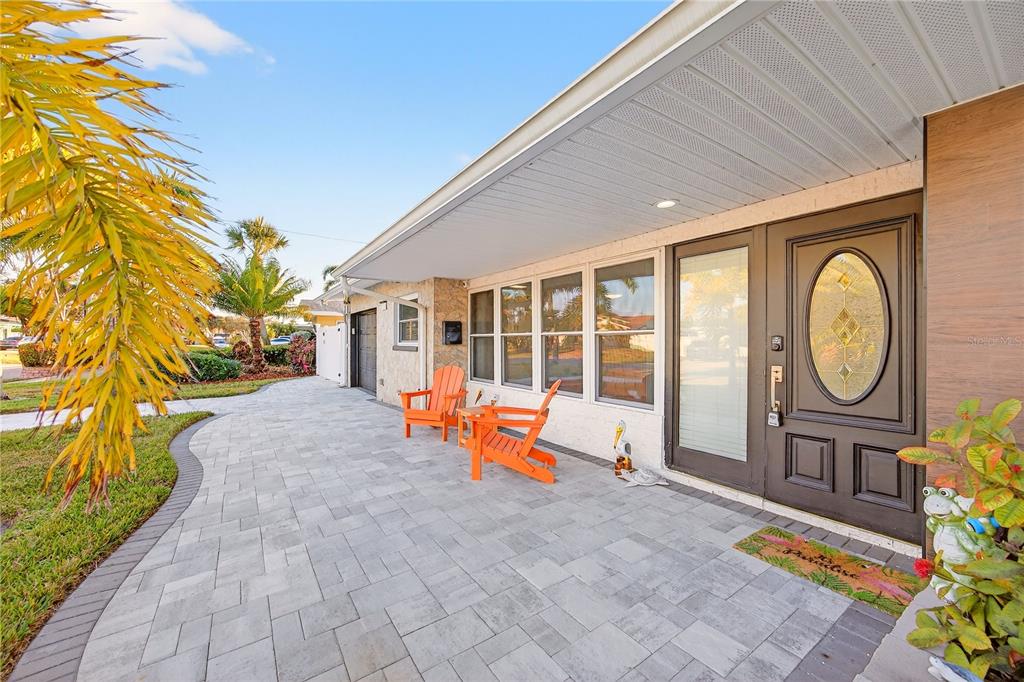 A paved patio features two orange chairs in front of a house with a front door — 5235 40TH STREET S, ST PETERSBURG, FL