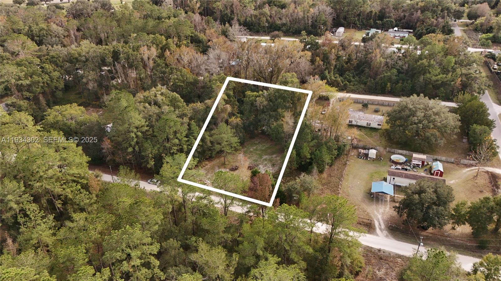 An aerial view shows a rectangular, wooded vacant lot outlined in white near a road — 0 Southwest 2nd Place, Ocala FL 34476, OCALA, FL