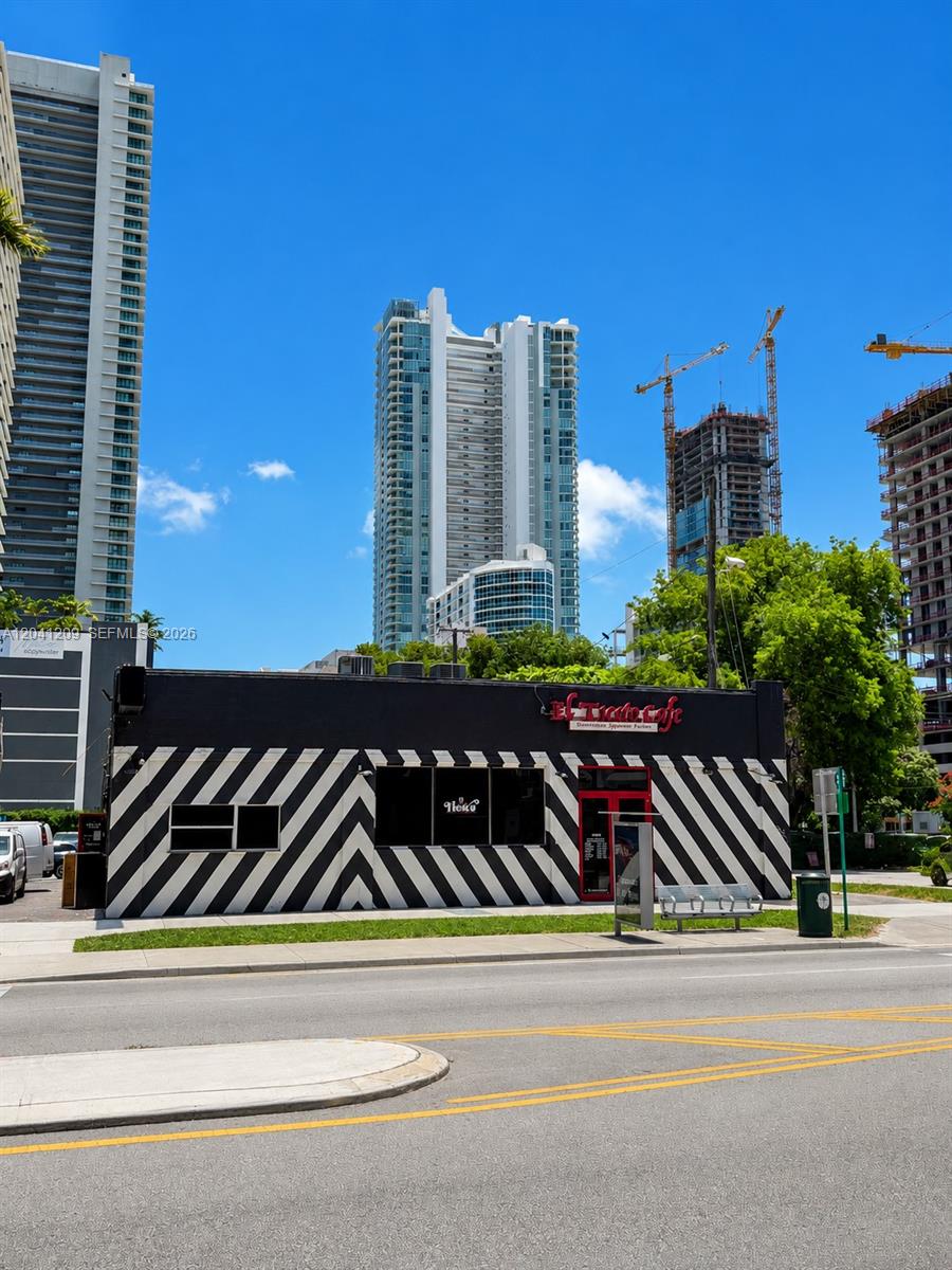 A black building with white diagonal stripes sits in front of tall city skyscrapers — 3023 Biscayne Blvd, Miami FL 33137, MIAMI, FL