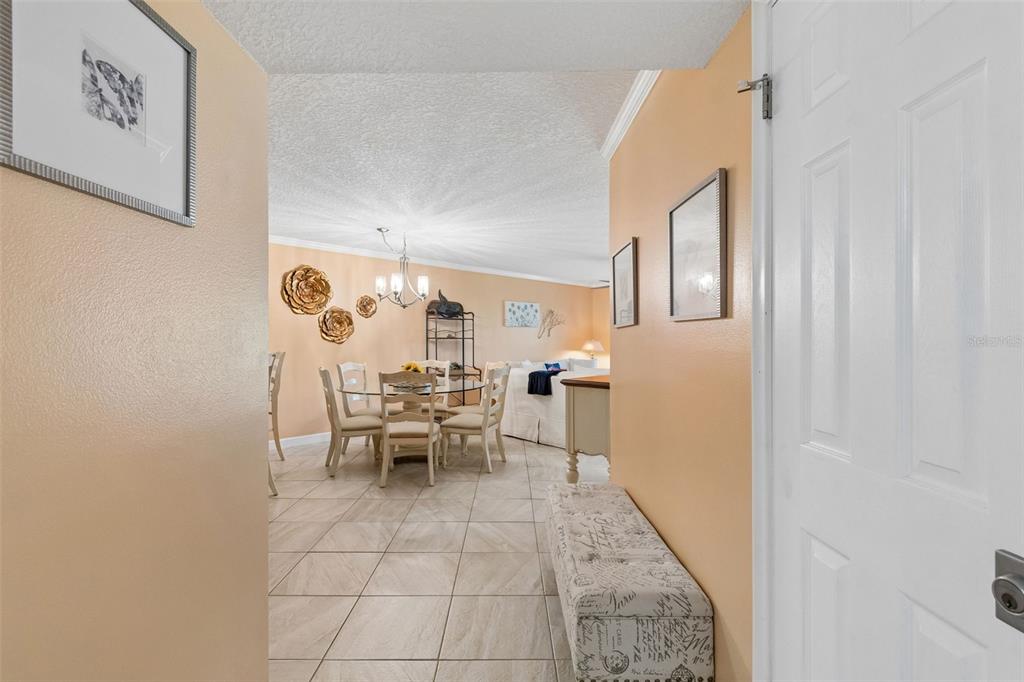 A tiled entryway leads into a dining area with a glass table and peach walls — 6085 BAHIA DEL MAR BOULEVARD UNIT 106, ST PETERSBURG, FL