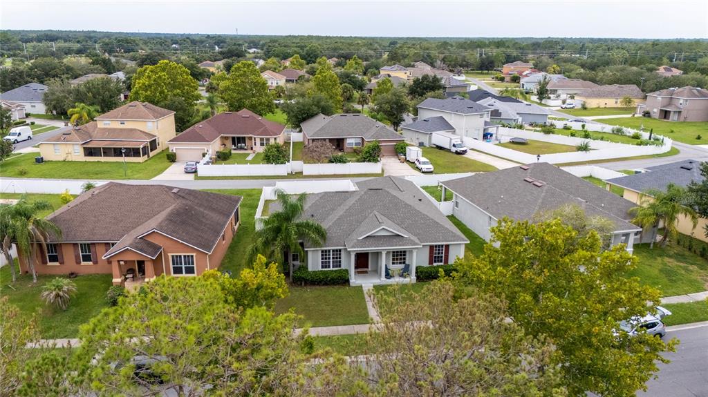 An aerial view shows several suburban single-family homes with pitched roofs and green lawns — 3108 WESTBROOK ROAD, KISSIMMEE, FL