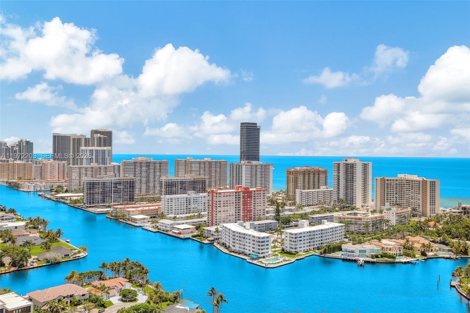 An aerial view shows a waterway surrounded by high-rise apartment buildings and coastal residential properties — 21200 Point Pl, Aventura FL 33180, AVENTURA, FL