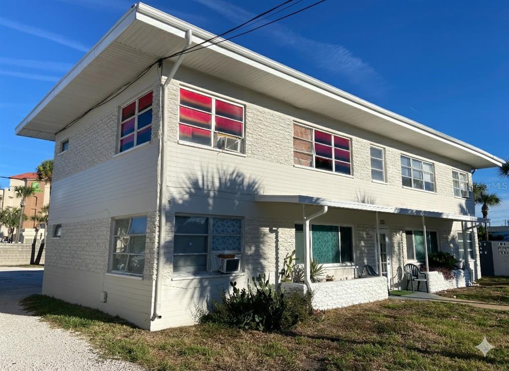 A two-story, light-colored apartment building with a flat roof and a gravel driveway — 938 N GRANDVIEW AVENUE, DAYTONA BEACH, FL